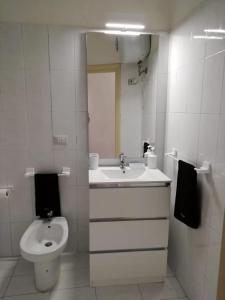 a white bathroom with a sink and a toilet at Alloggio Turistico Casa Vicolo Pincio in Grotte di Castro