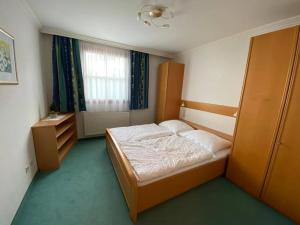 a small bedroom with a bed and a window at Ferienwohnung Schnaitl in Maria Alm am Steinernen Meer +2 photos