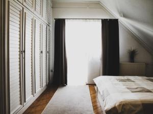 a bedroom with a bed and a large window at Anita Apartman in Csopak