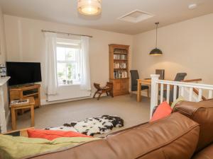 una sala de estar con sofá y un perro tirado en el suelo en Crag End Cottage en Grange Over Sands