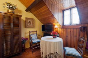 Zimmer mit einem Tisch, 2 Stühlen und einem TV in der Unterkunft Hostal Casa Blasquico - Restaurante Gaby in Hecho