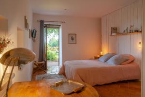 a bedroom with a bed and a table in it at La douce France in Collonges la rouge