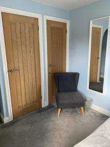 a blue room with a chair and a mirror at 15 Maple Court in Oxford