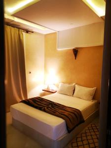 ein Hotelzimmer mit einem Bett mit einer Lampe in der Unterkunft My Home Mirelft in Mirleft