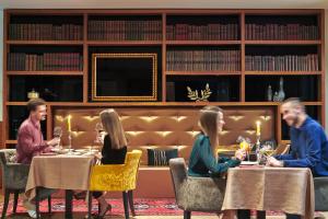 a group of people sitting at tables in a restaurant at Marmont Heritage Hotel in Split