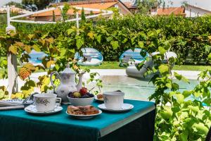 a table with cups and plates of food on it at il buen retiro in Lucca