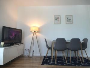 a dining room with a table and chairs and a television at Apartament Wielbark Królowej Jadwigi 4m2 in Wielbark