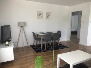 a living room with a table and chairs and a tv at Apartament Wielbark Królowej Jadwigi 4m2 in Wielbark
