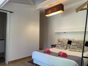 ein Schlafzimmer mit einem Bett mit zwei rosa Kissen darauf in der Unterkunft Hotel et Résidence Chez Gino Le Touquet-Etaples in Étaples