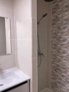 baño blanco con ducha y lavamanos en Hotel et Résidence Chez Gino Le Touquet-Etaples, en Étaples