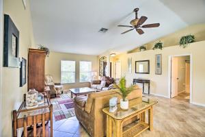 a living room with a couch and a ceiling fan at Cape Coral Canalfront Home with Pool and Dock in Cape Coral