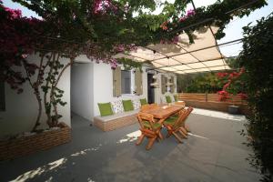 patio z drewnianym stołem i krzesłami w obiekcie STATHI'S COTTAGE w mieście Divarata
