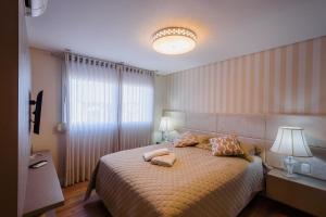 um quarto com uma cama com duas toalhas em Serra Nevada Apartamento- Vista Catedral de Pedra em Canela