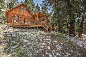 a log cabin with a large deck in the woods at Peaceful and Private Cloudcroft Cabin with Deck! in Cloudcroft