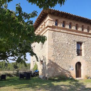 un edificio de ladrillo con una ventana en el lateral en Masia Del Aragones, en Peñarroya de Tastavins