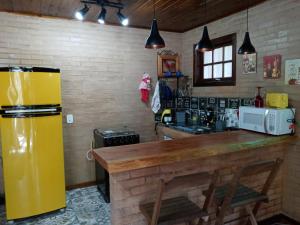 a kitchen with a yellow refrigerator and a counter at Eco Chalés Águas Claras in Lumiar