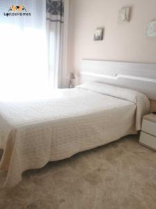 ein Schlafzimmer mit einem weißen Bett mit einem Fenster in der Unterkunft LyriosHomes Beach Costa Ballena in Chipiona