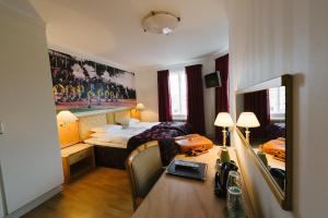 a hotel room with a bed and a desk in it at Eksjö Stadshotell Annex in Eksjö