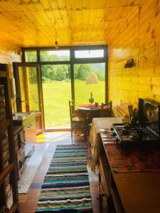 una sala de estar con una gran ventana en una cabaña de madera en La Container en Curtea de Argeş
