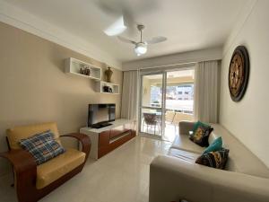 - un salon avec un canapé et une télévision dans l'établissement Garden Ville · Confortável apartamento na Praia de Bombas com ótima localização, à Bombinhas