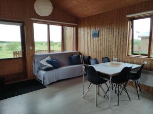 ein Wohnzimmer mit einem Tisch, Stühlen und einem Sofa in der Unterkunft Rjúpnavellir in Rjúpnavellir