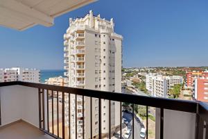 a balcony with a view of a tall white building at Armacao de Pera Ocean View by Homing in Armação de Pêra