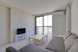 uma sala de estar com um sofá, uma mesa e uma televisão em Armacao de Pera Ocean View by Homing em Armação de Pêra