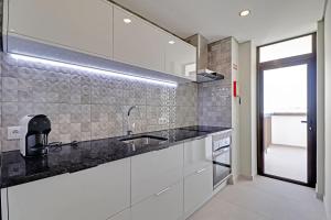 a kitchen with white cabinets and a sink at Armacao de Pera Ocean View by Homing in Armação de Pêra