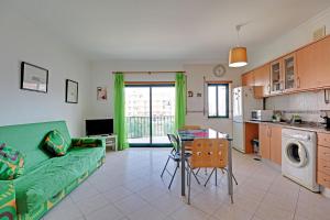 a living room with a green couch and a table at Armacao de Pera Central by Homing in Armação de Pêra