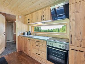 eine Küche mit einem Herd und einem Fenster in der Unterkunft Petzen Cottages - Petzen Chalets in Bleiburg