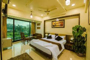 a bedroom with a large bed and a dining room at La Hotel Metro near BKC in Mumbai