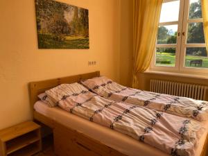 Bett in einem Schlafzimmer mit Wandgemälde in der Unterkunft Schloss Lelkendorf, FeWo Groß Gievitz in Lelkendorf