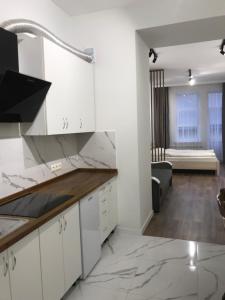una cucina con mobili bianchi e un soggiorno di Фурманська, 3 (центр) a Lviv