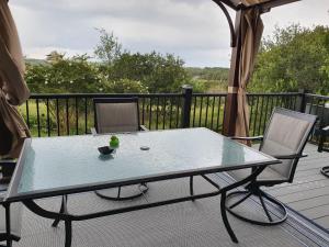 einen Glastisch und zwei Stühle auf einer Terrasse in der Unterkunft Hilltop Hacienda in San Marcos