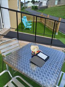 a table on a balcony with a laptop on it at O Chaleco in San Ciprián