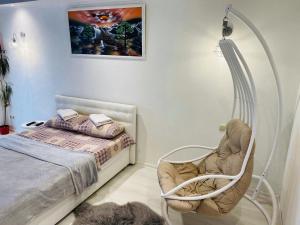 a bedroom with a bed and a chair and a lamp at Apartments on Polytech in Kyiv