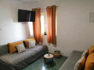 a living room with a couch and a tv at Holiday house Lara in Starigrad