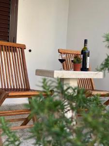 dos botellas y dos vasos de vino sentados en una mesa en Guest house Kamelija, en Budva