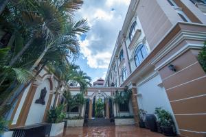 a building with palm trees in front of it at Reaksmey Chanreas Hotel in Siem Reap