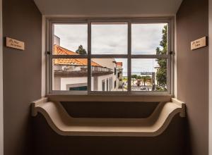 okno z widokiem na budynek w obiekcie Zarco B&B Bed & Breakfast w Funchal