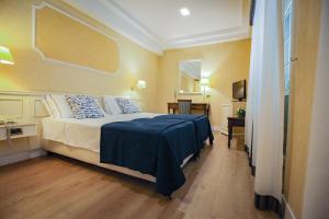 a bedroom with a large bed with a blue blanket at Hotel I Gigli in Nola