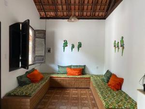 a room with two benches with orange and green pillows at Casa para temporada - Praia de Alcobaça - Bahia - em frente ao Condomínio Gaivotas in Alcobaça