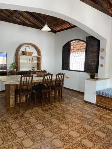 a kitchen with a table and chairs in a room at Casa para temporada - Praia de Alcobaça - Bahia - em frente ao Condomínio Gaivotas in Alcobaça