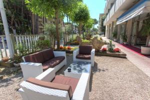 a patio with couches and chairs on a sidewalk at New Hotel Chiari in Cervia