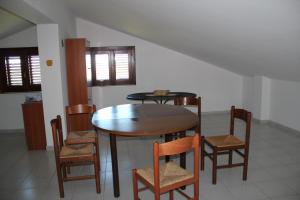 a dining room with a wooden table and chairs at Gli Aranci Dell'Etna in Mascali