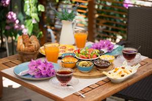 einen Holztisch mit Teller mit Speisen und Getränken in der Unterkunft Cenar Konak Butik Hotel in Büyükada