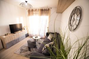 a living room with a couch and a clock on the wall at Island View Luxury Apartments in Zadar
