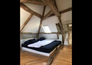 a bedroom with a large bed in a room with wooden floors at Maison d'hôtes de Charme in Bayeux