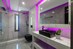 Rua Mat Villas في أليكيس: حمام مع حوض أسود وإضاءة أرجوانية
