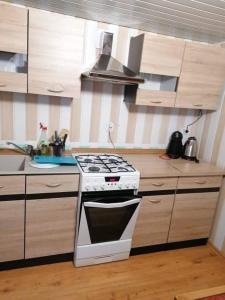 a kitchen with a white stove and wooden cabinets at Domek w Sławie przy jeziorze na Galerach in Sława